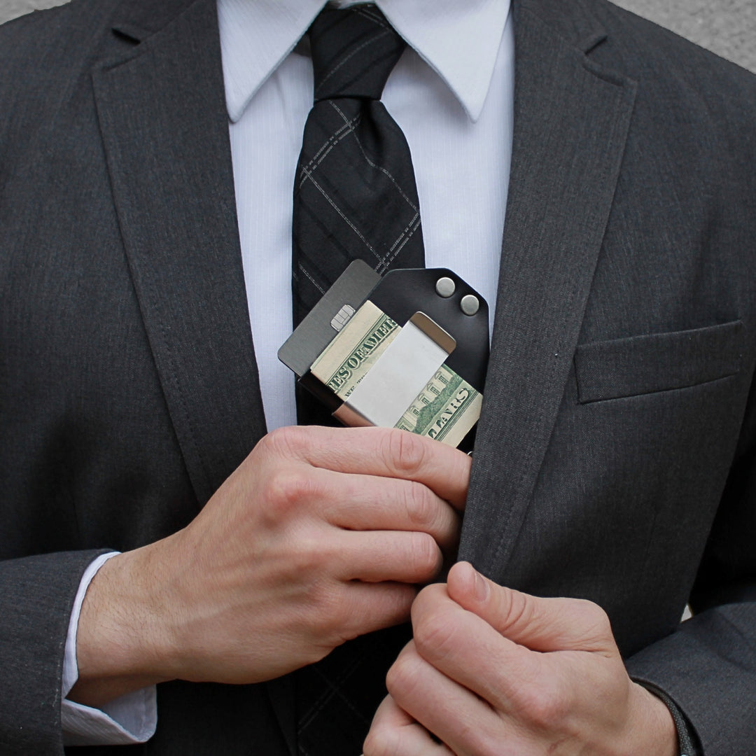 Person in a suit holding a caliber clip with money